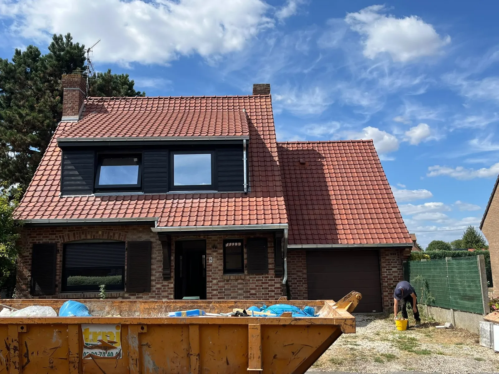 Façade avant de la maison à Provin avec toiture à deux pans en tuiles rouges et lucarne bardée de noir