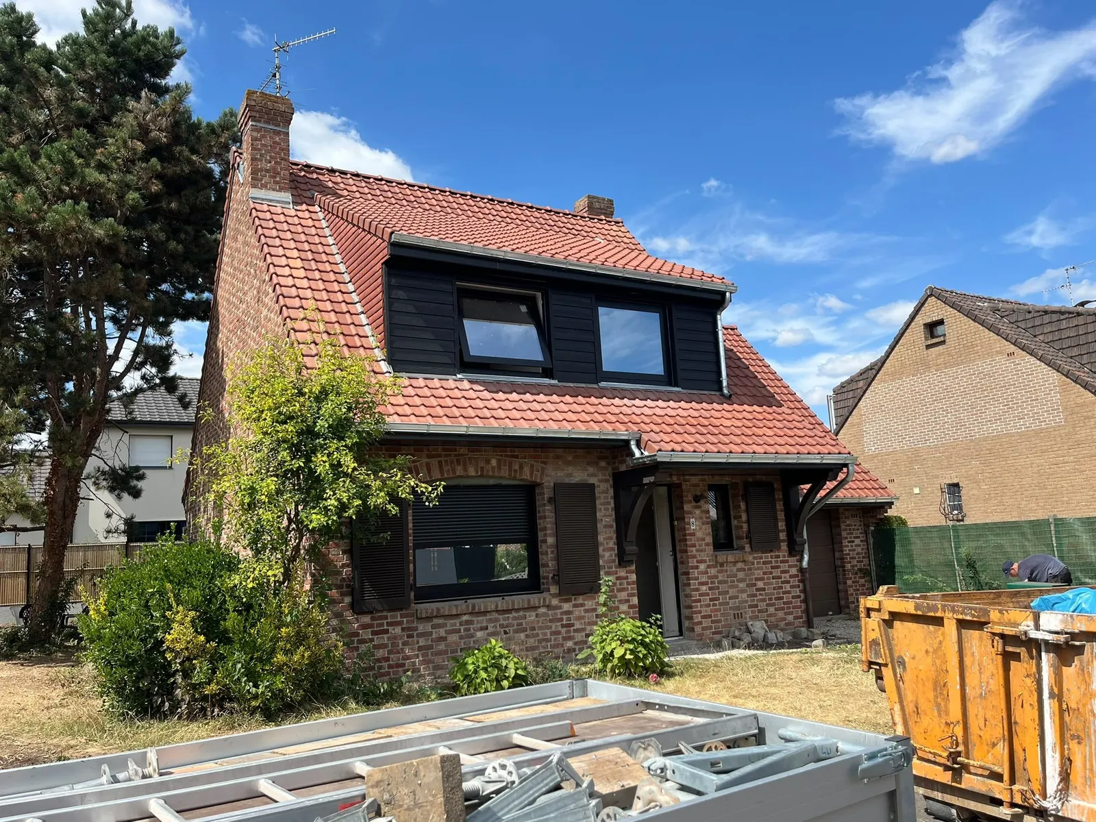 Maison de Provin vue de côté, lucarne bardée de lames noires, tuiles rouges et gouttières en zinc naturel